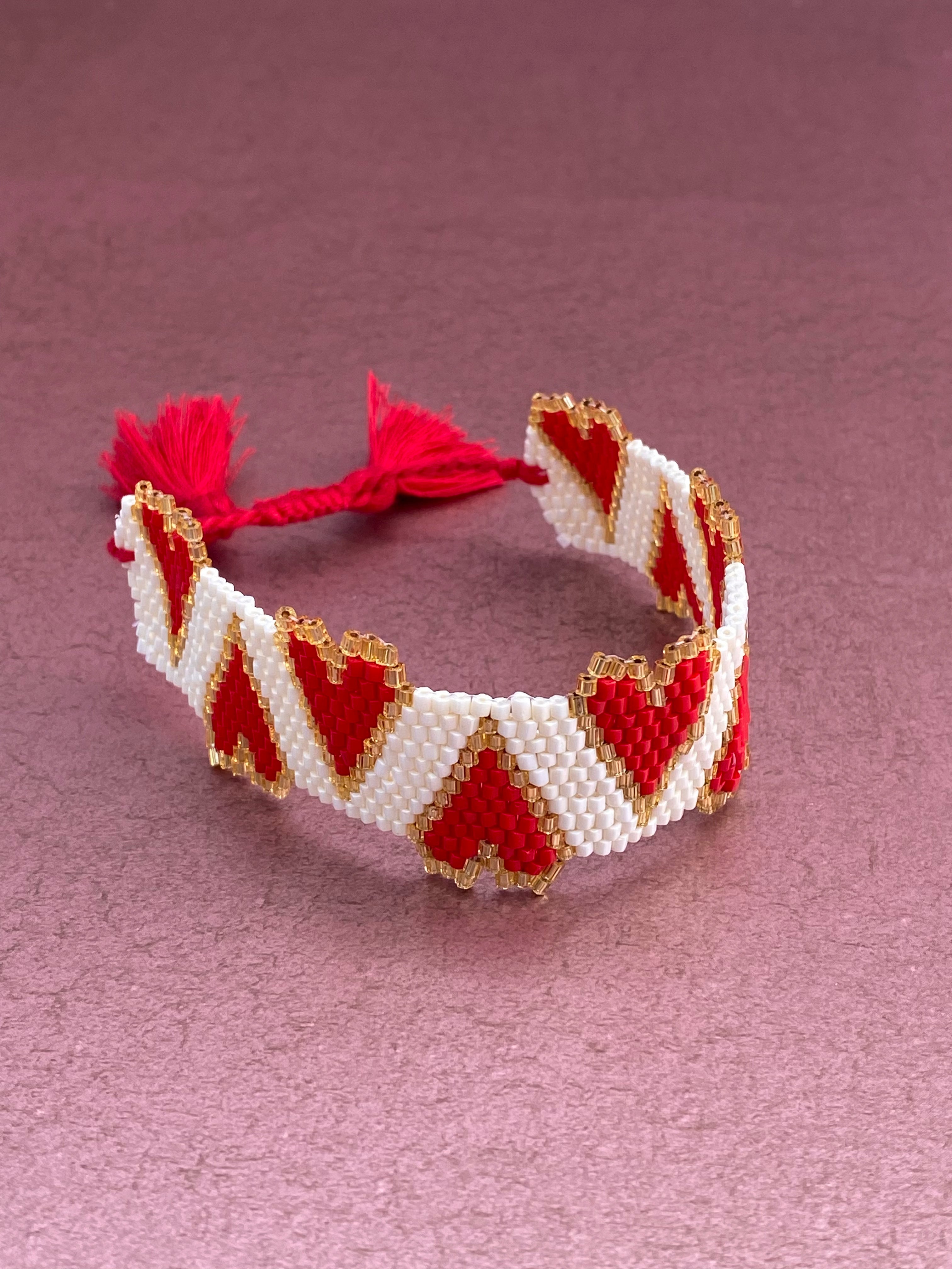 Beaded Bracelet White with Red Hearts Trimmed in Gold Tassel Closure